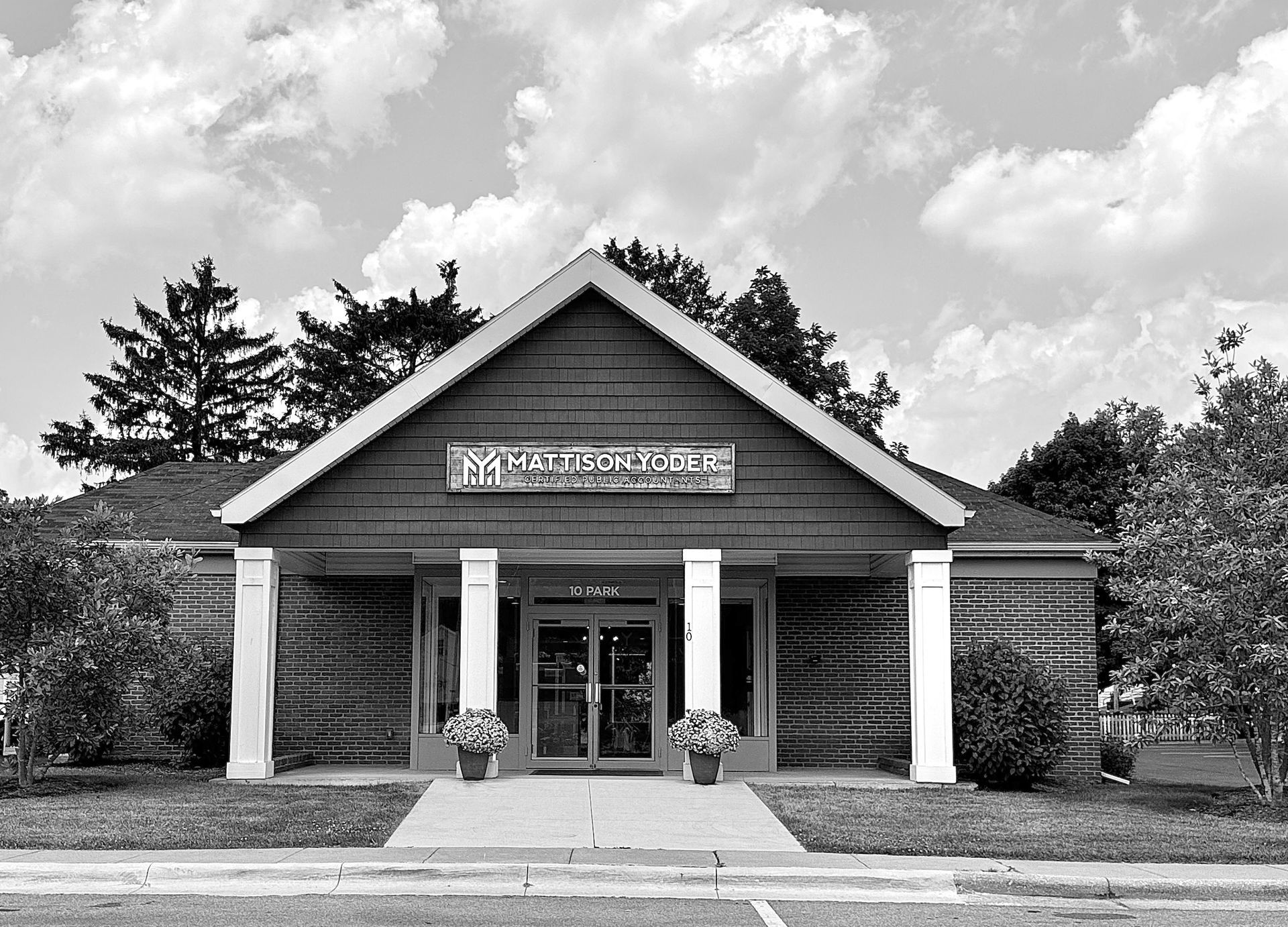 A black and white photo of the front of a log cabin