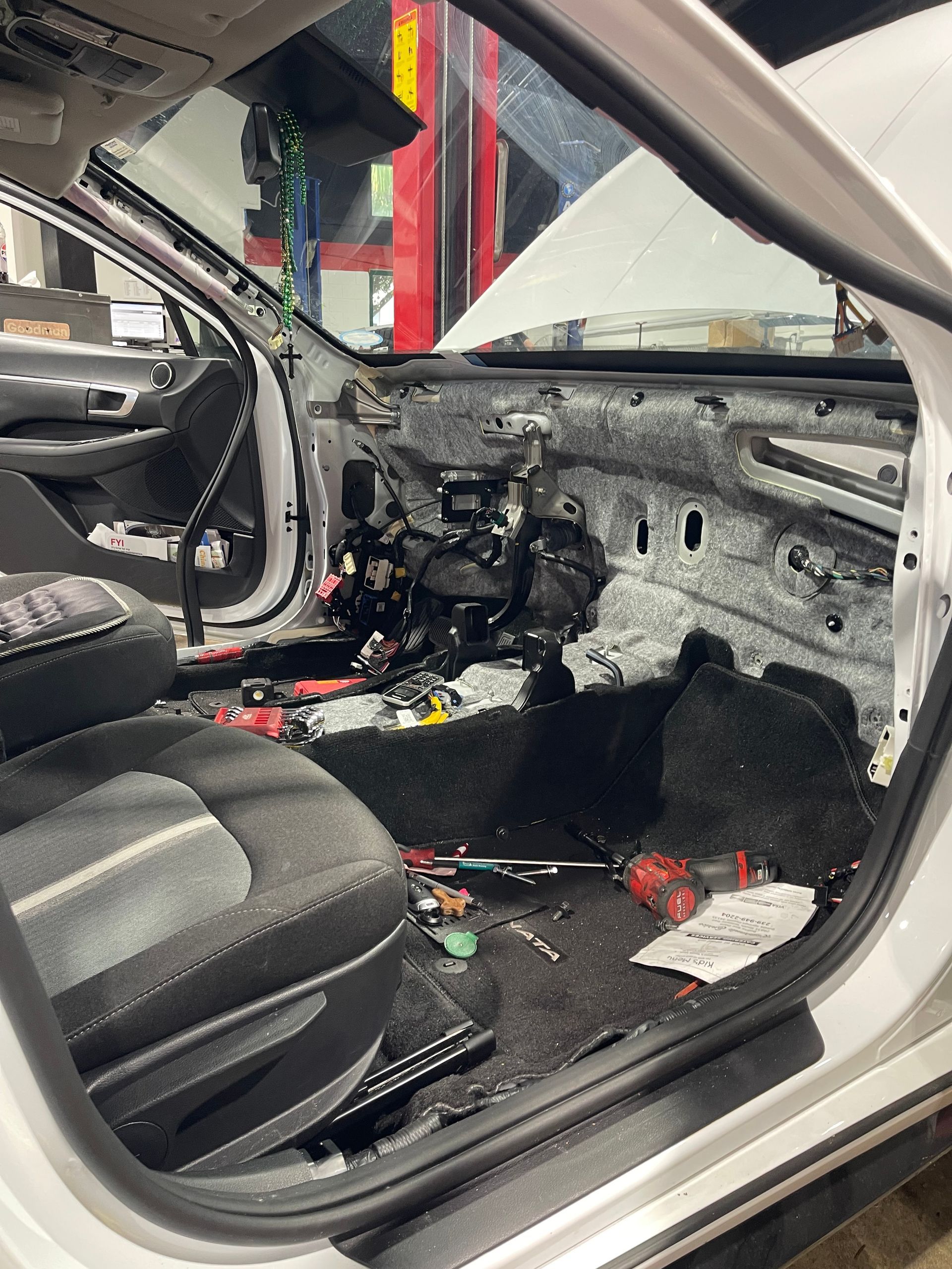 Charred car interior with stripped dashboard, burned seats, and melted debris after fire damage.
