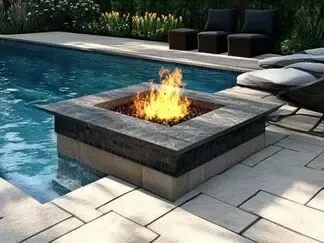 Modern backyard pool with a square fire pit and flame beside lounge chairs and cushions