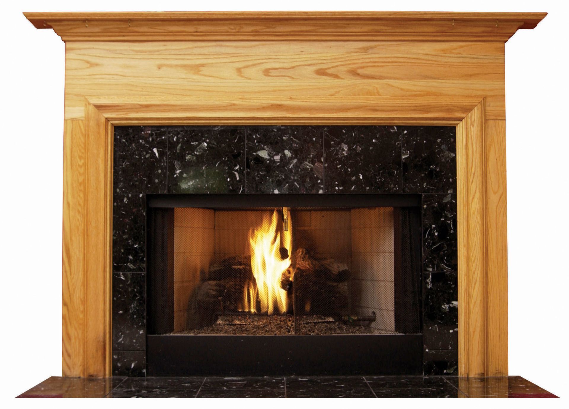 Wooden fireplace surround with black marble tile and burning fire.