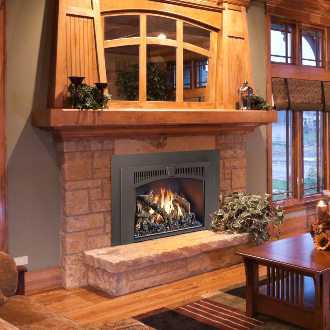 Fireplace with stone surround, wood mantel, and interior gas fire, in a living room.