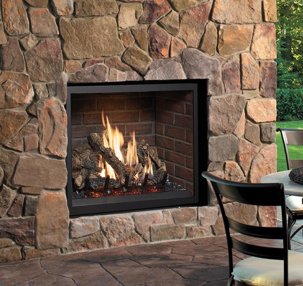 Outdoor fireplace with burning logs, brick interior, surrounded by a stone facade.