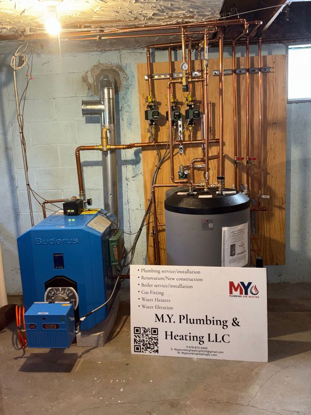 Blue furnace and water heater with copper pipes in a basement.