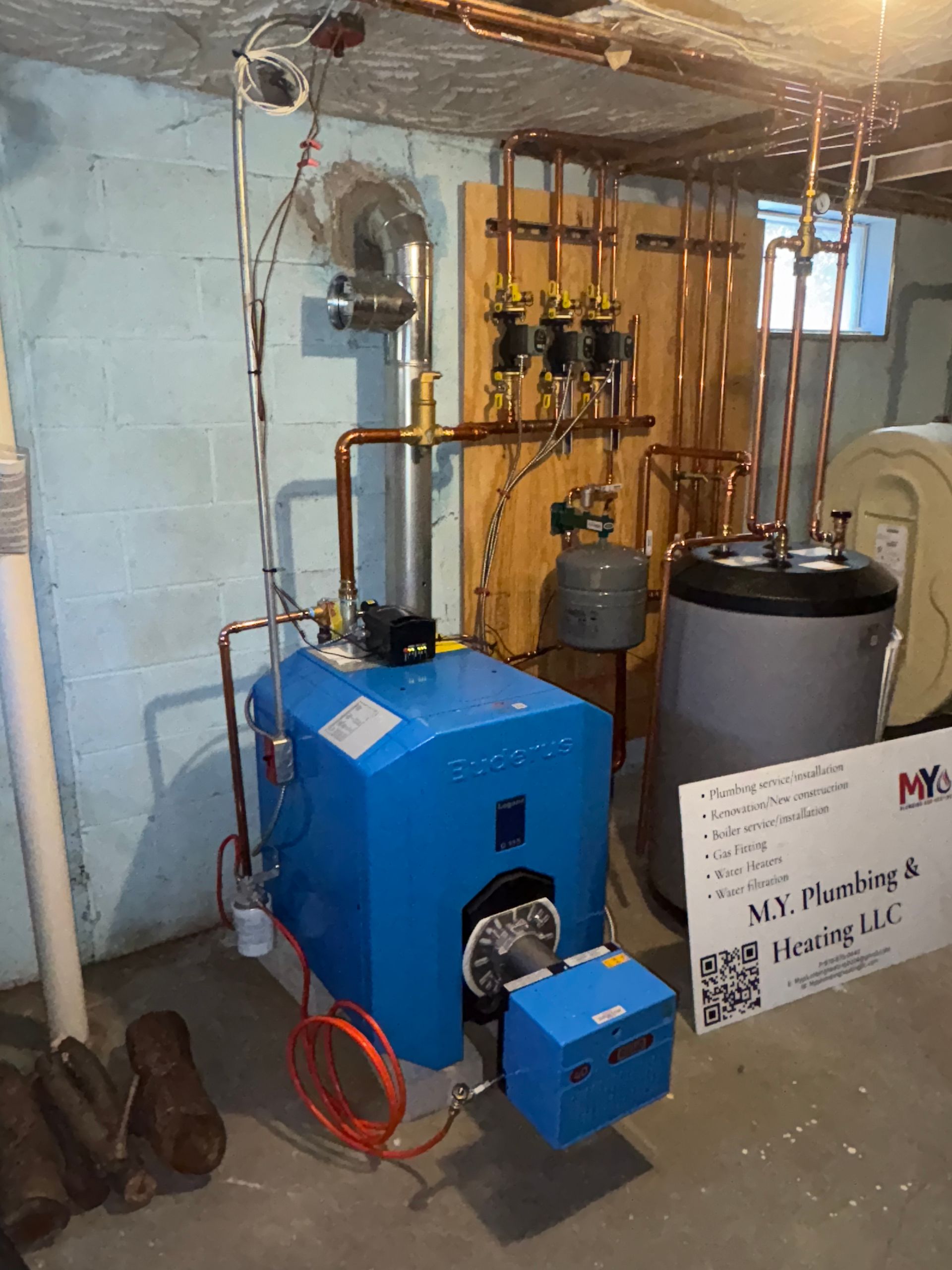 Blue heating system in basement with copper pipes.