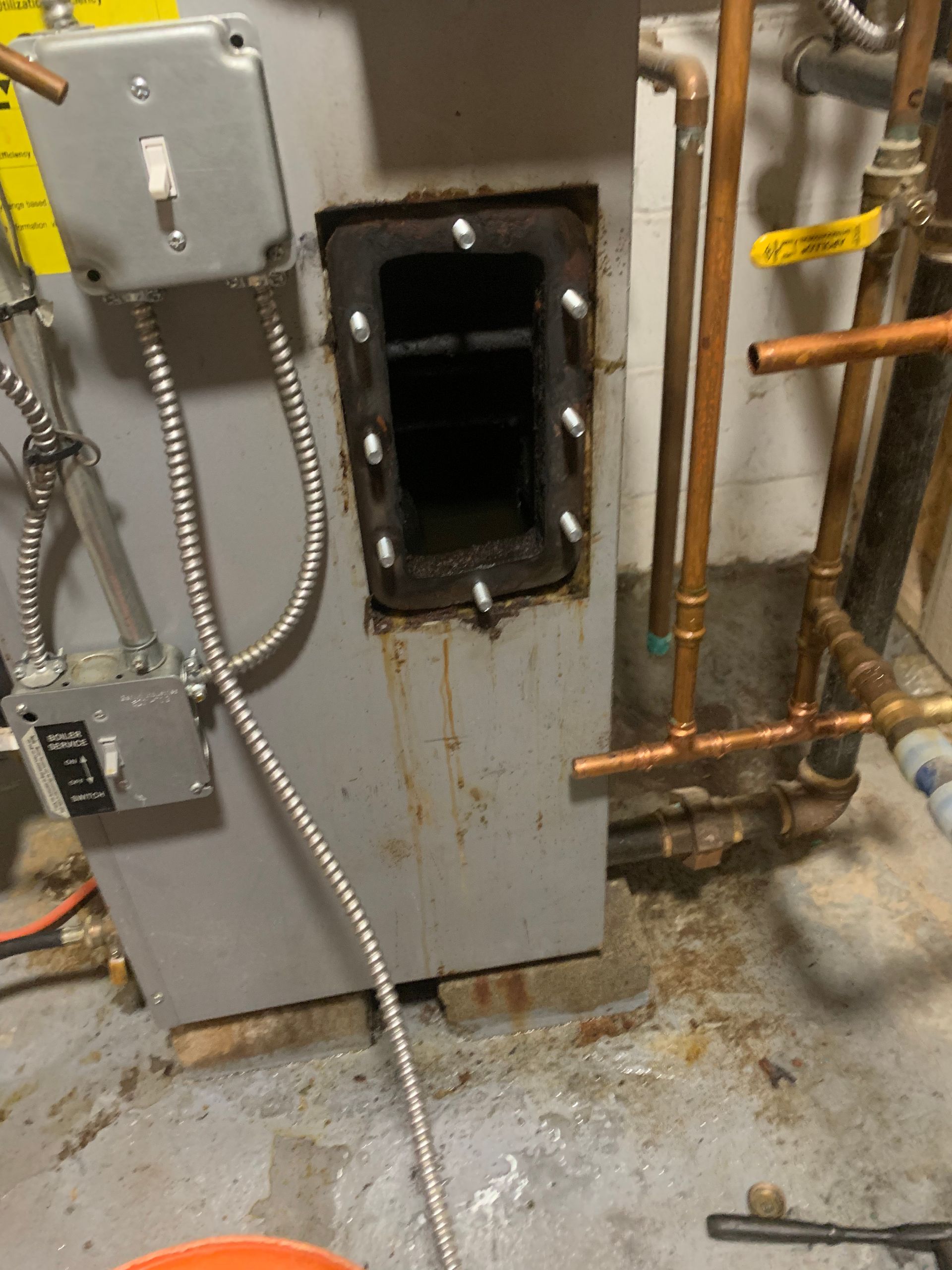 Industrial heating unit, open access panel revealing interior. Metal components, electrical wiring, copper pipes.