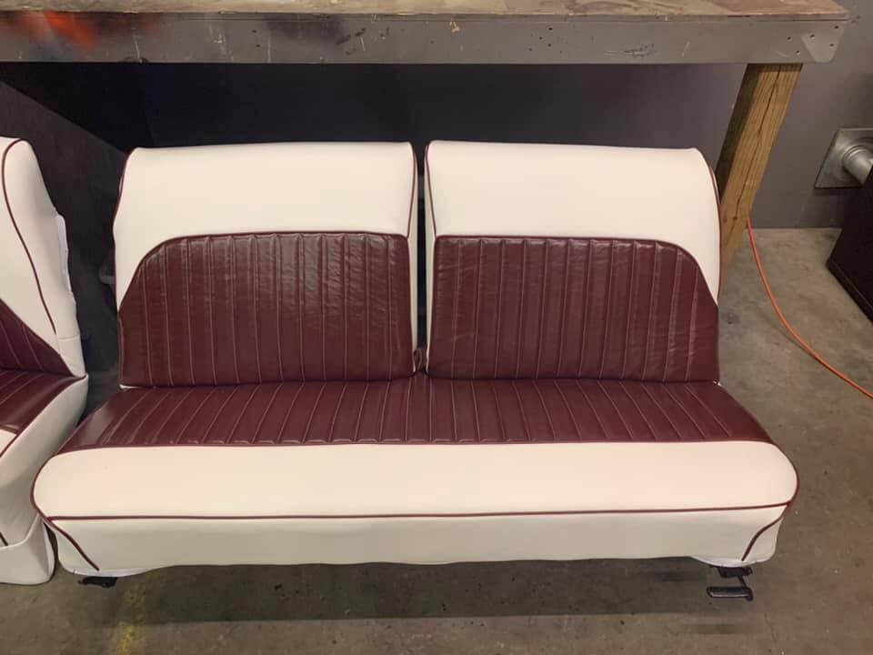 Maroon and white boat seats in workshop.