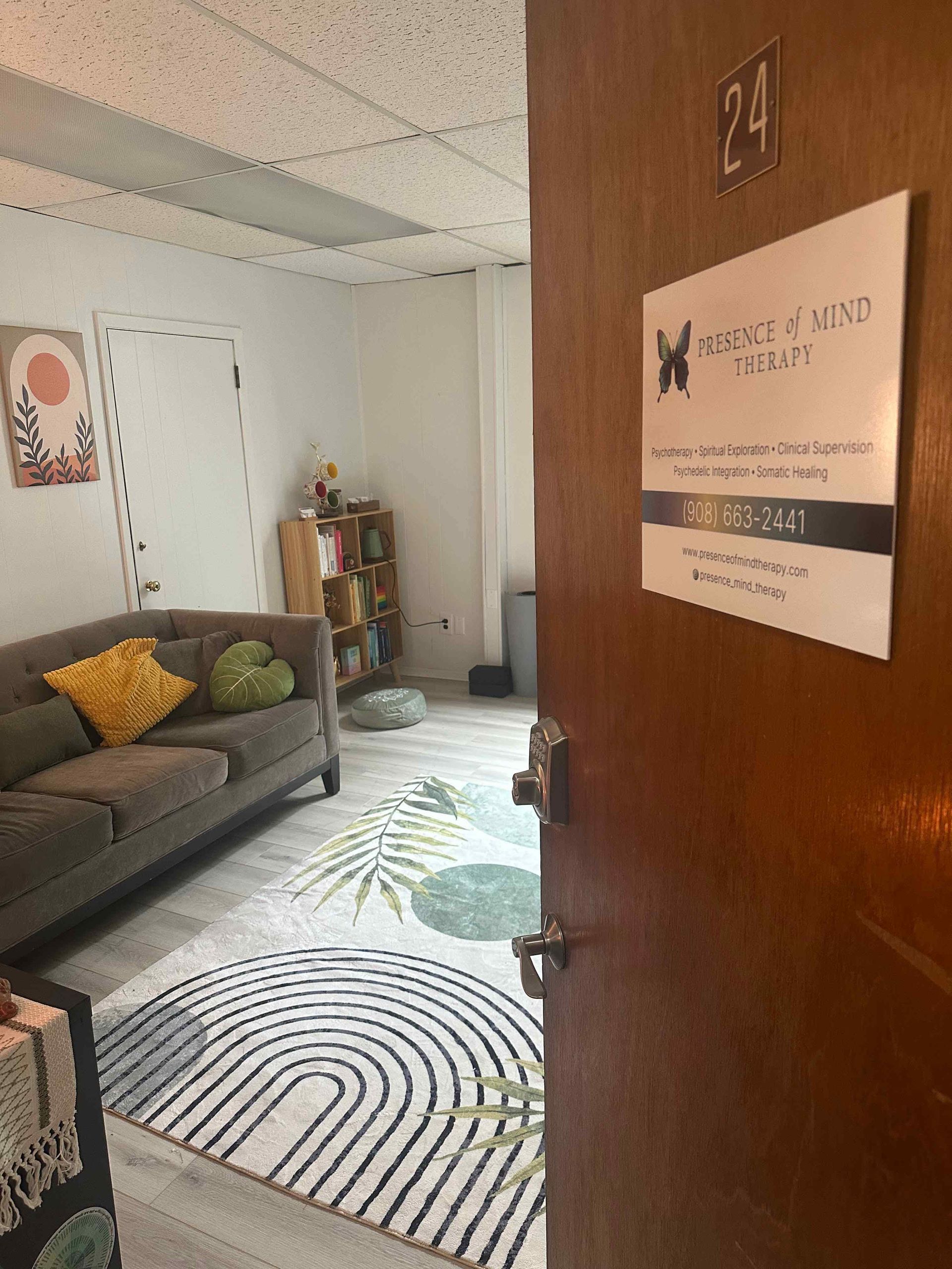 Person seated, using a mallet on a frosted quartz singing bowl, performing sound therapy.
