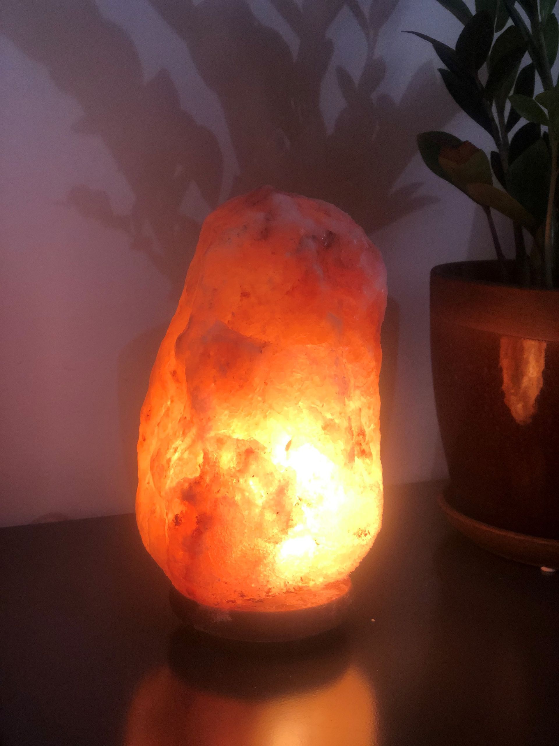 Person meditating on the beach, hand in mudra, sunlight.