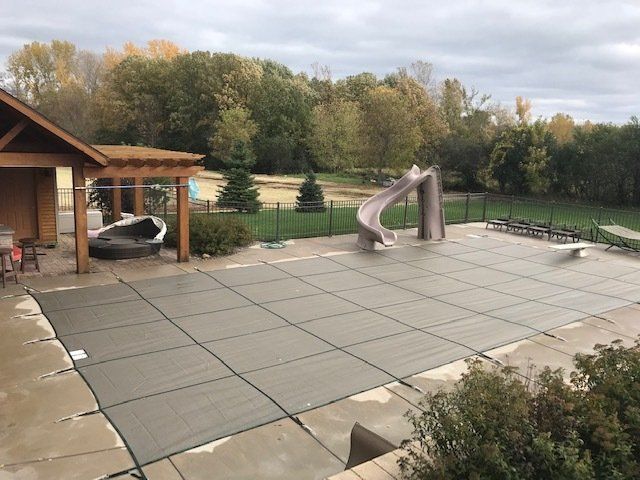 A large swimming pool with a slide and a pergola