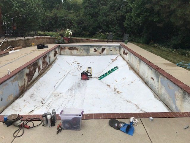 An empty swimming pool with tools on the side of it