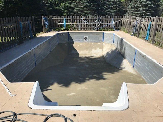 An empty swimming pool with a fence in the background