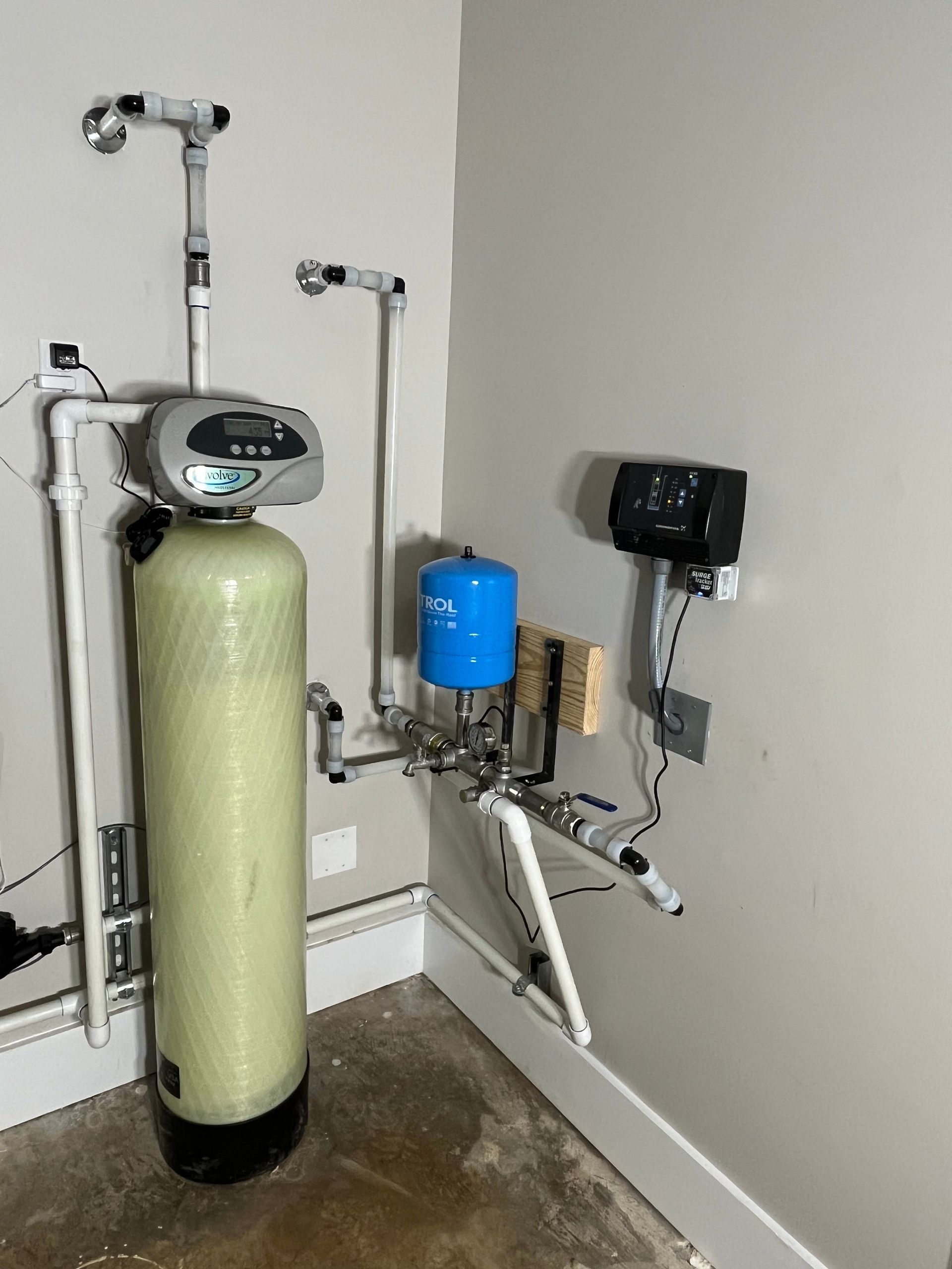 A water filter is sitting in a room next to a wall.