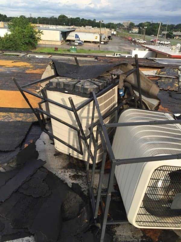 Damaged rooftop with HVAC units; burned debris and metal framework.