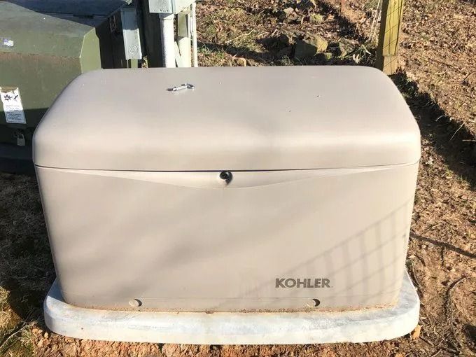 Gray Kohler generator in an outdoor setting, on a concrete pad.
