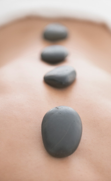 A person is getting a massage with hot rocks on their back.