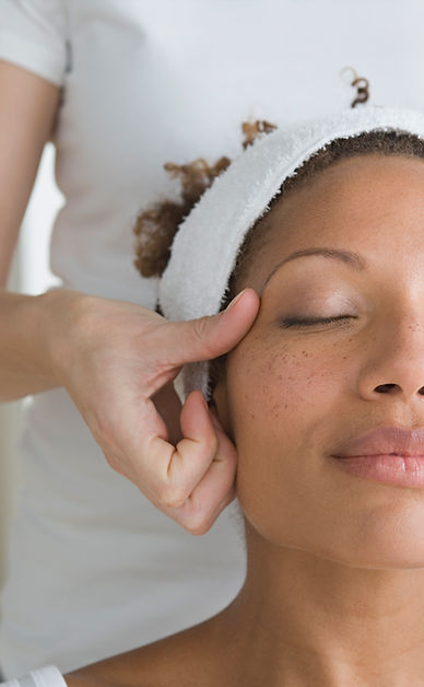 A woman with a towel wrapped around her head is getting a massage.