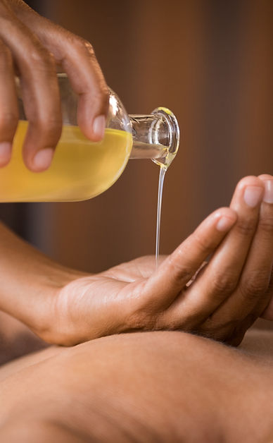 A person is getting a massage from a bottle of oil.