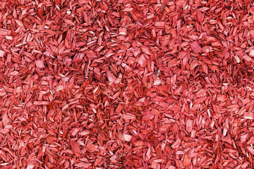 A pile of red mulch is sitting on the ground.