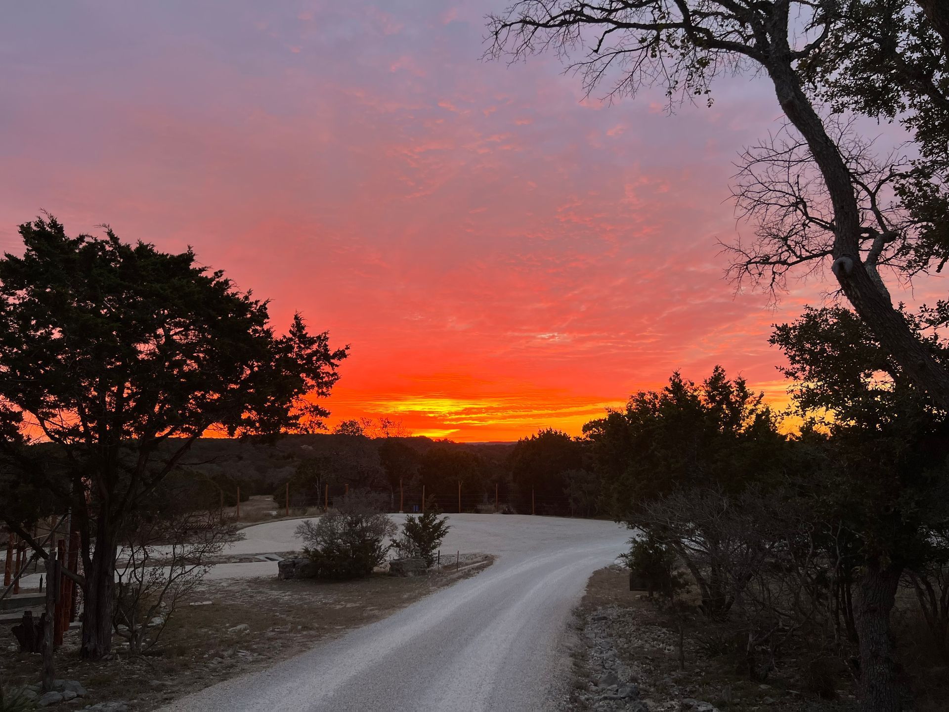 An RV park road with a sunset in the background.