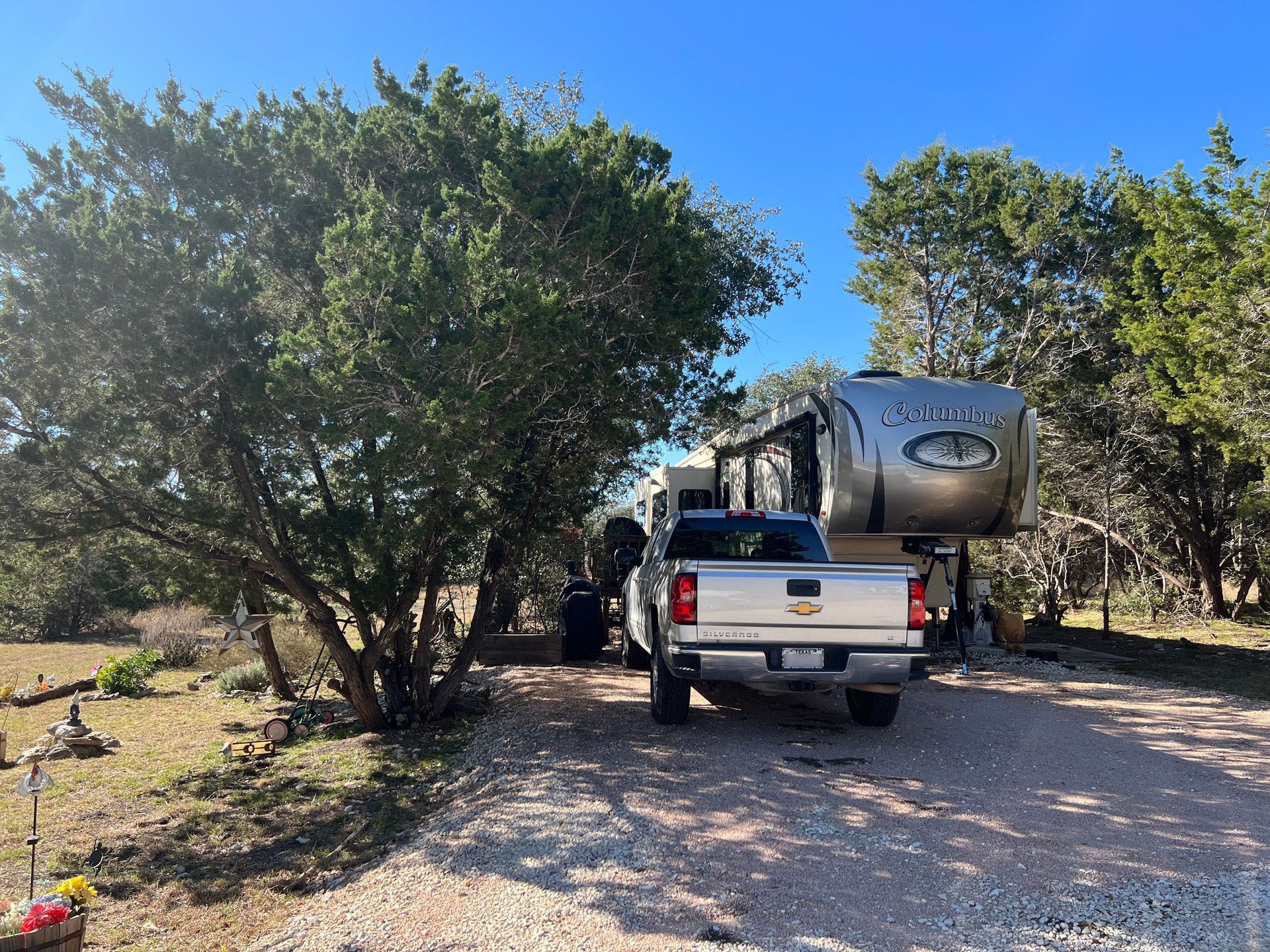 A truck is parked in a gravel road next to an RV.