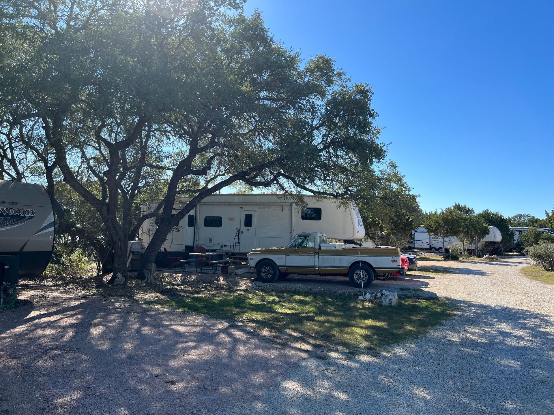 A truck is parked next to an RV in a parking lot.