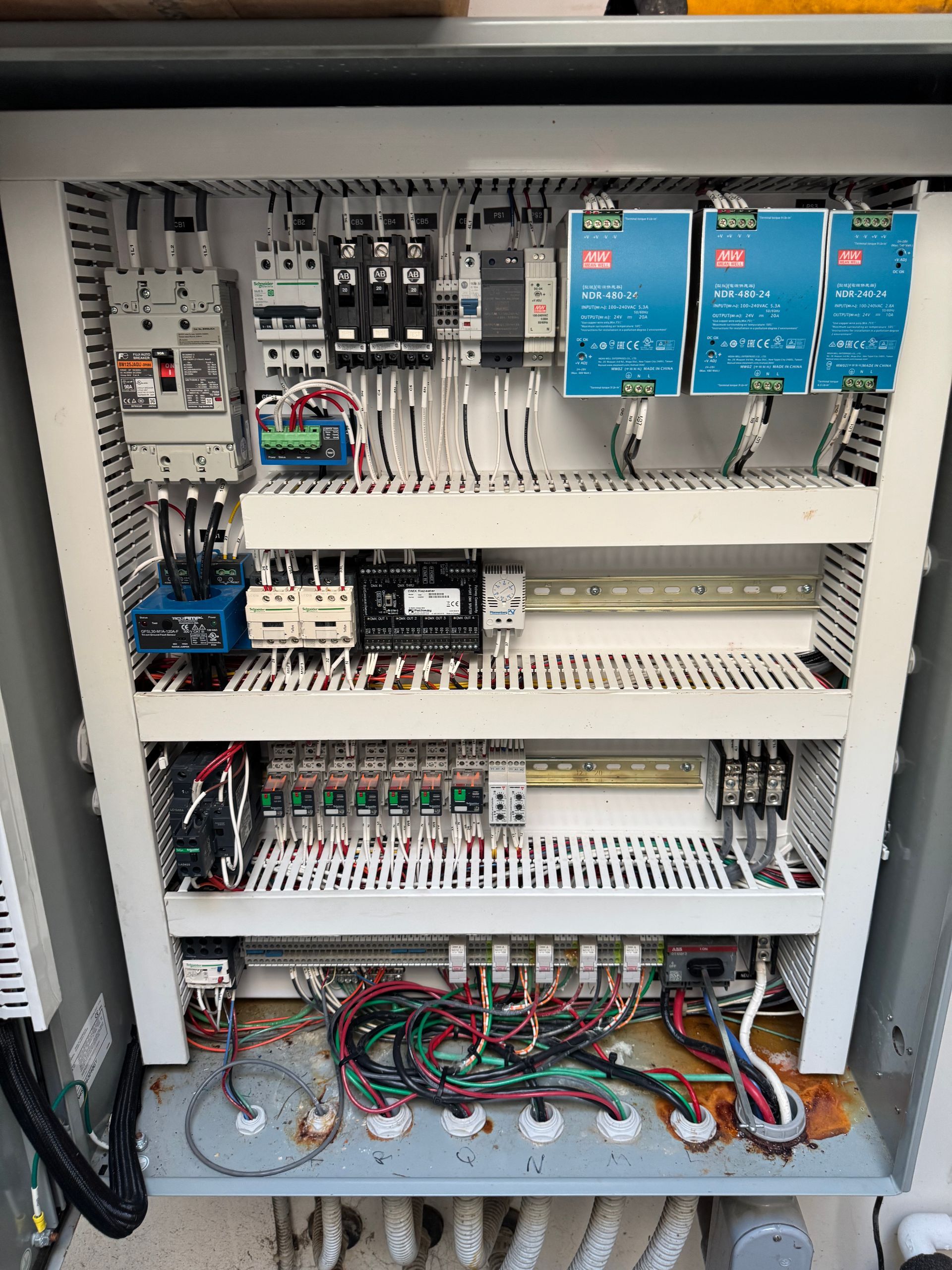 Electrical control panel with wires, relays, and circuit breakers.