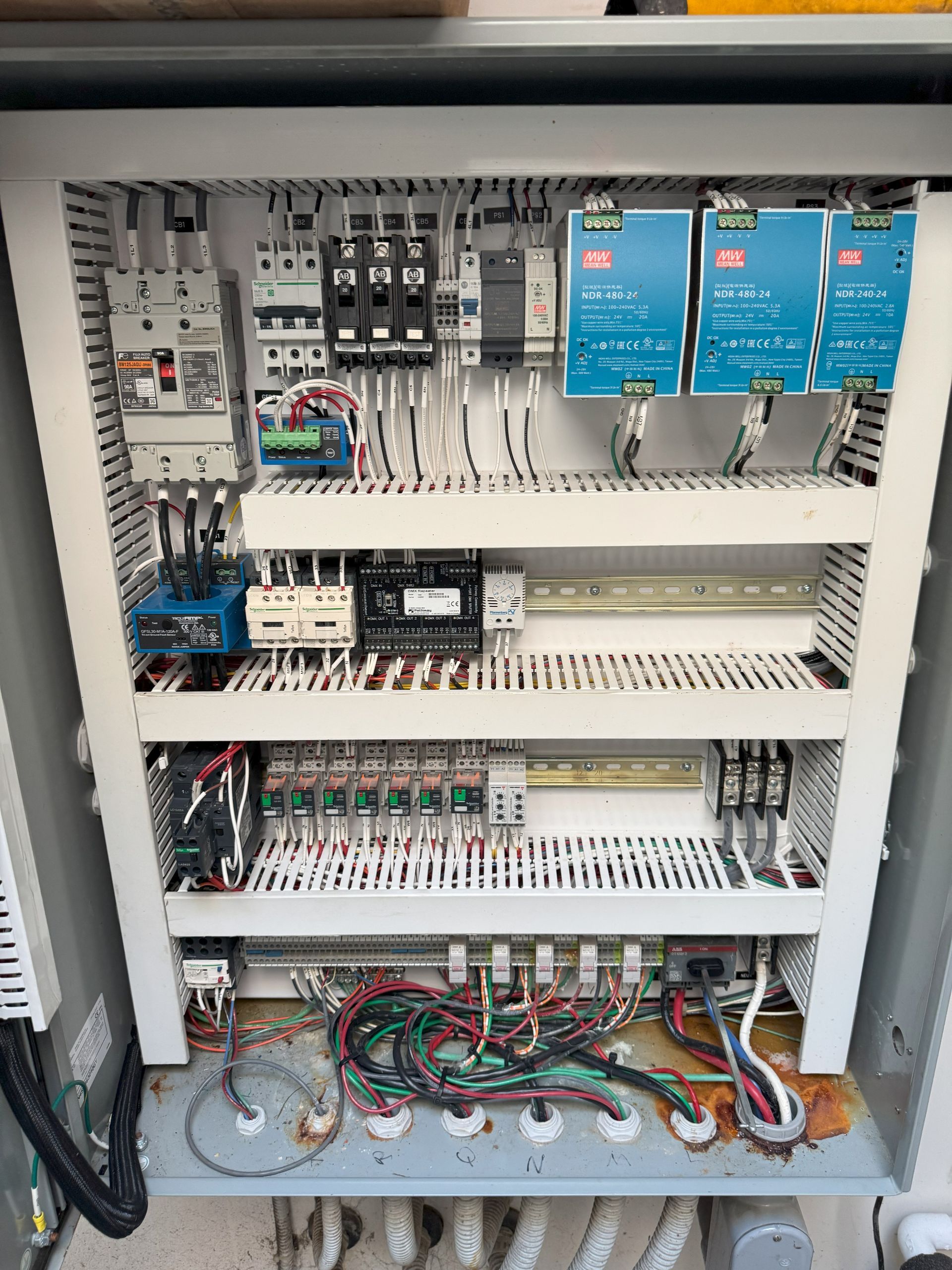 Electrical control panel with various components and wiring inside a gray cabinet.