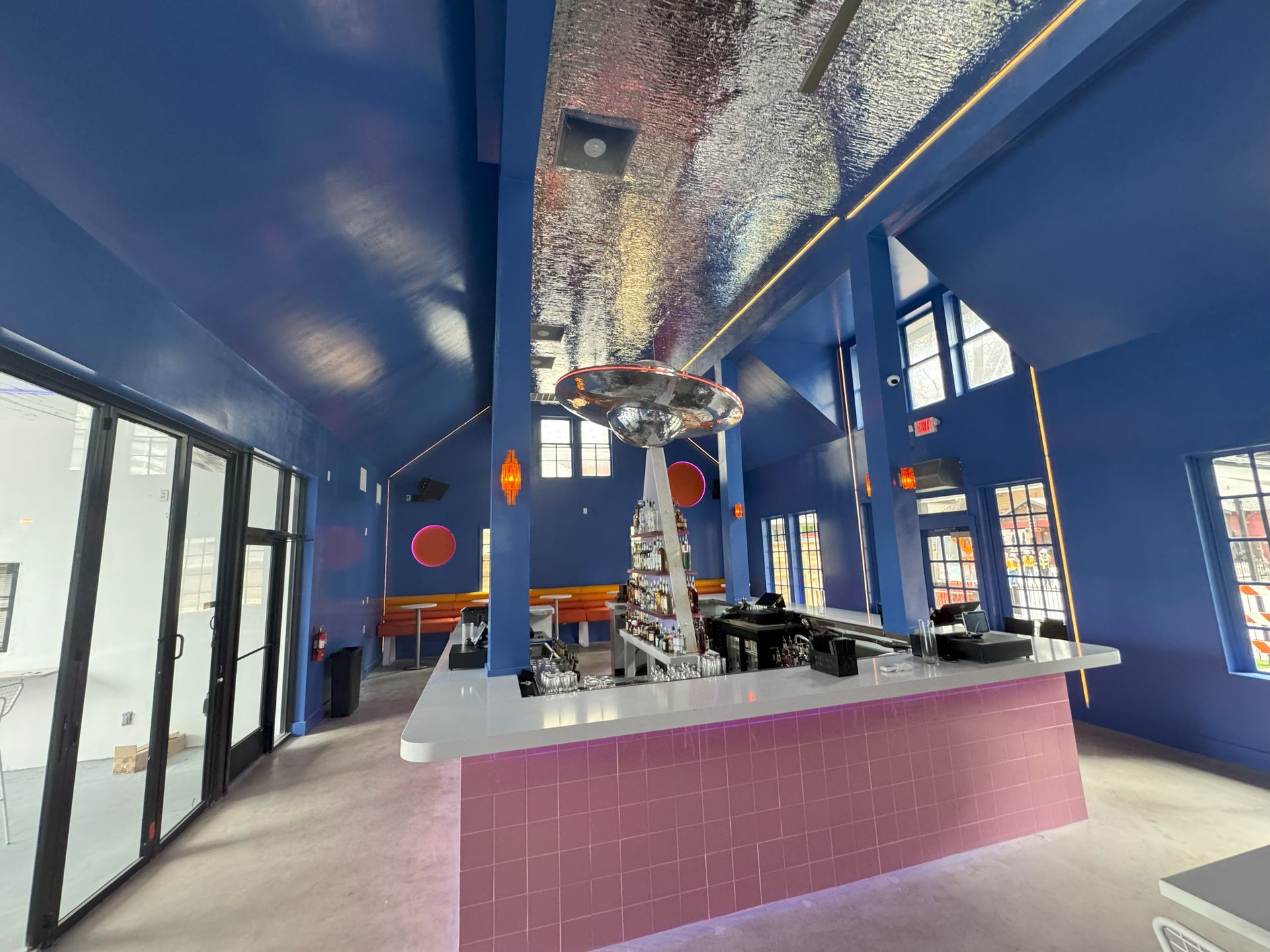 Blue and pink interior with a bar and mirrored ceiling, possibly a restaurant.