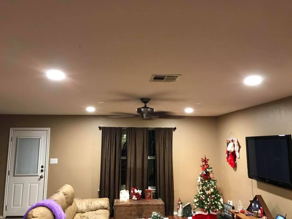 Living room with a Christmas tree, TV, and dark brown curtains.
