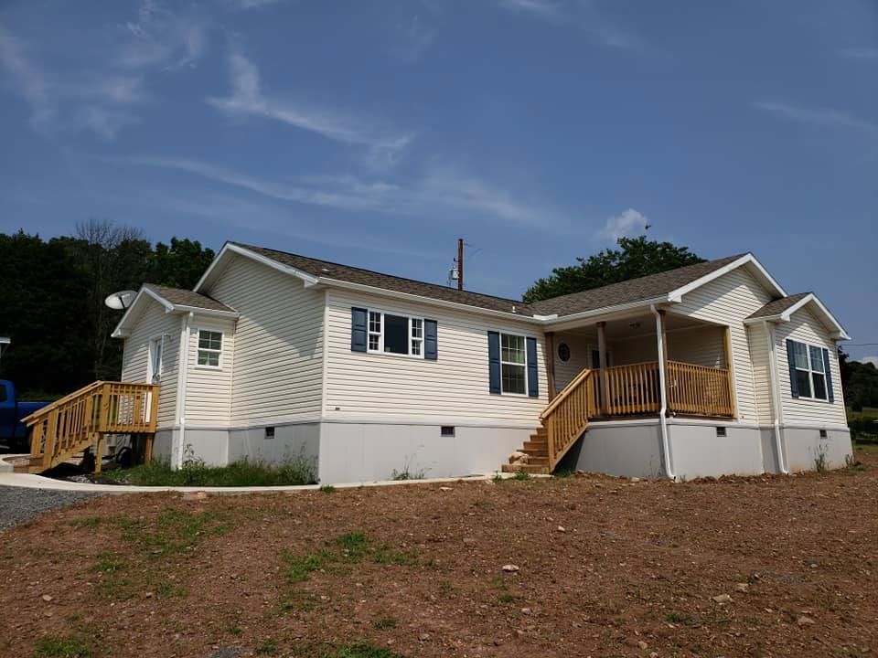 A white mobile home with a porch and stairs