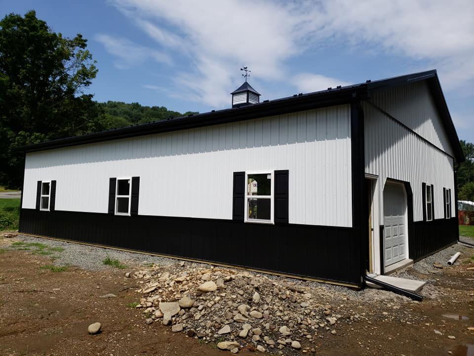 A black and white building with shutters on the windows