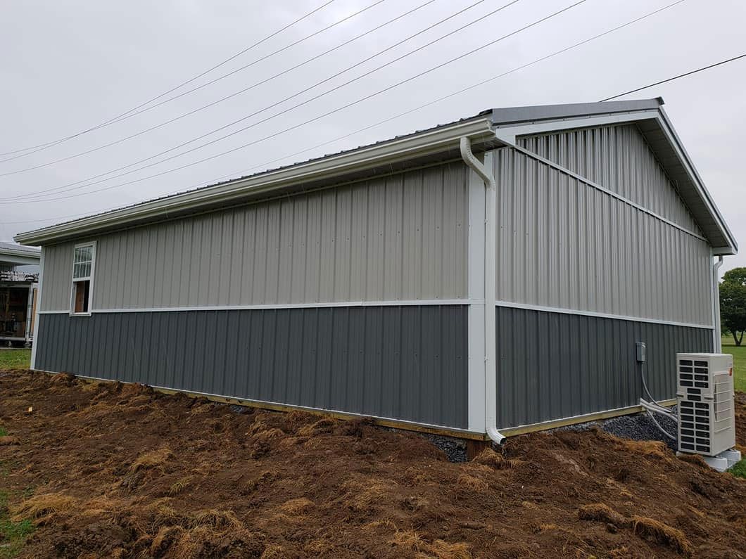 A large metal building is sitting on top of a pile of dirt.