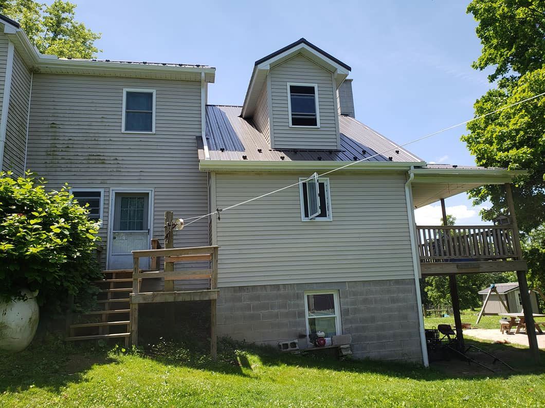The back of a house with a deck and a clothes line.