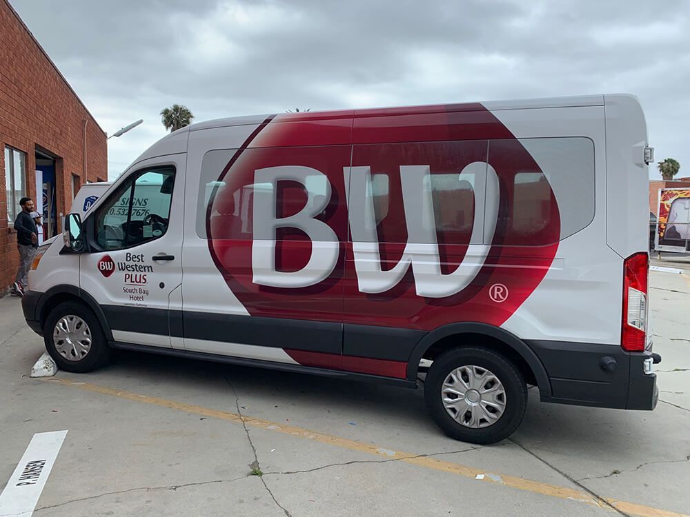 A white and red van with the word bw on the side is parked in a parking lot.