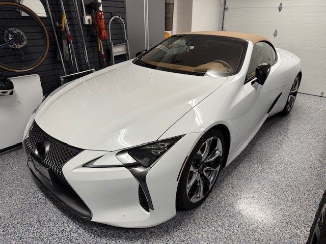 White sports coupe parked in a garage, front-left view