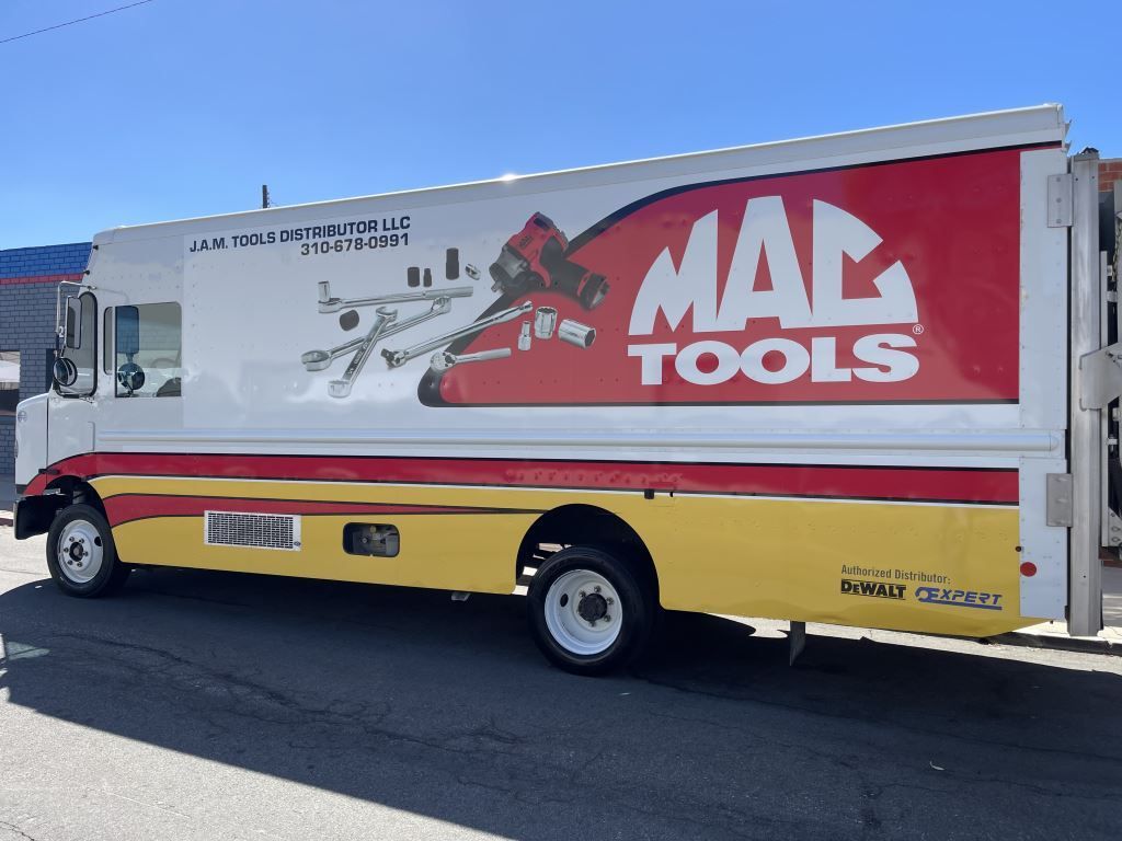 MAC Tools delivery truck with red-and-white logo parked outdoors on a sunny day