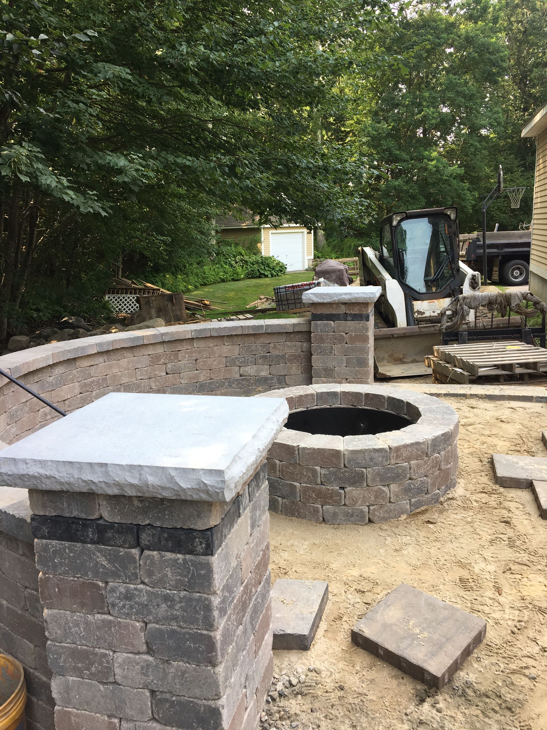 A fire pit is being built in a backyard