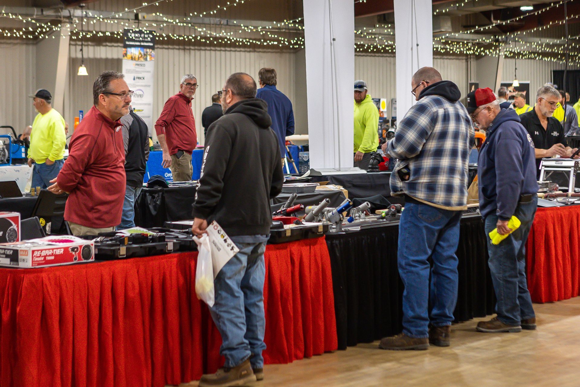 An image of a group of men standing around a table talking to each other.