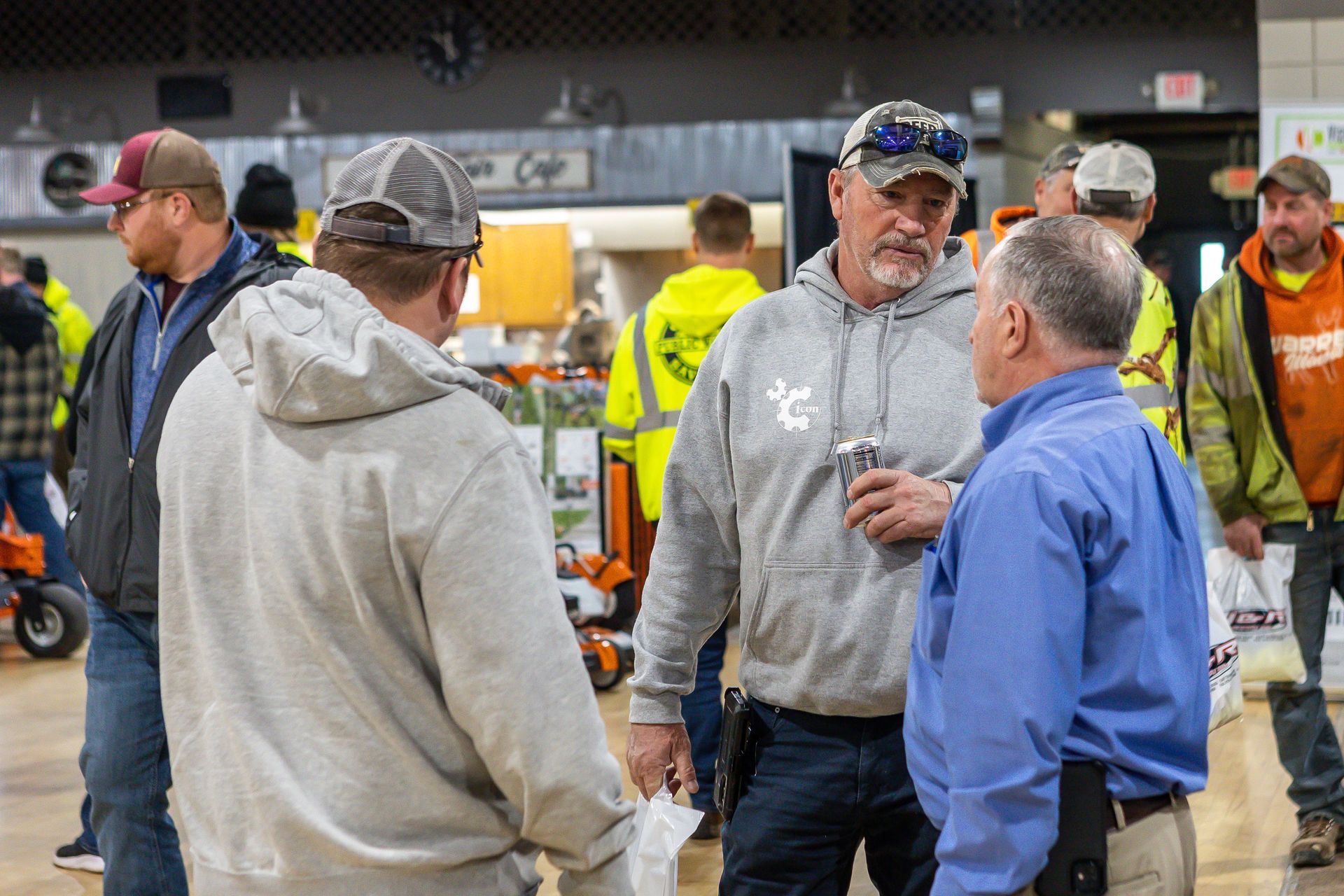 A picture of a group of men standing in a room talking to each other.