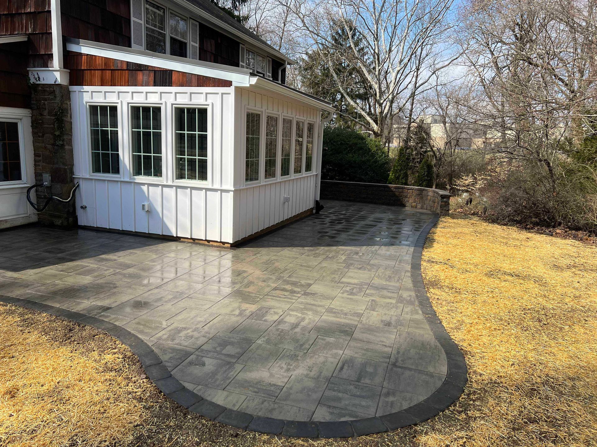 A white house with a large patio in front of it.