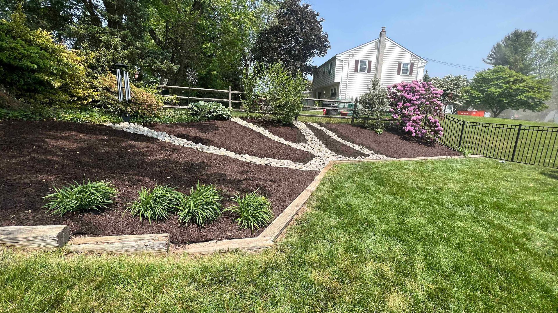A lush green yard with a house in the background.