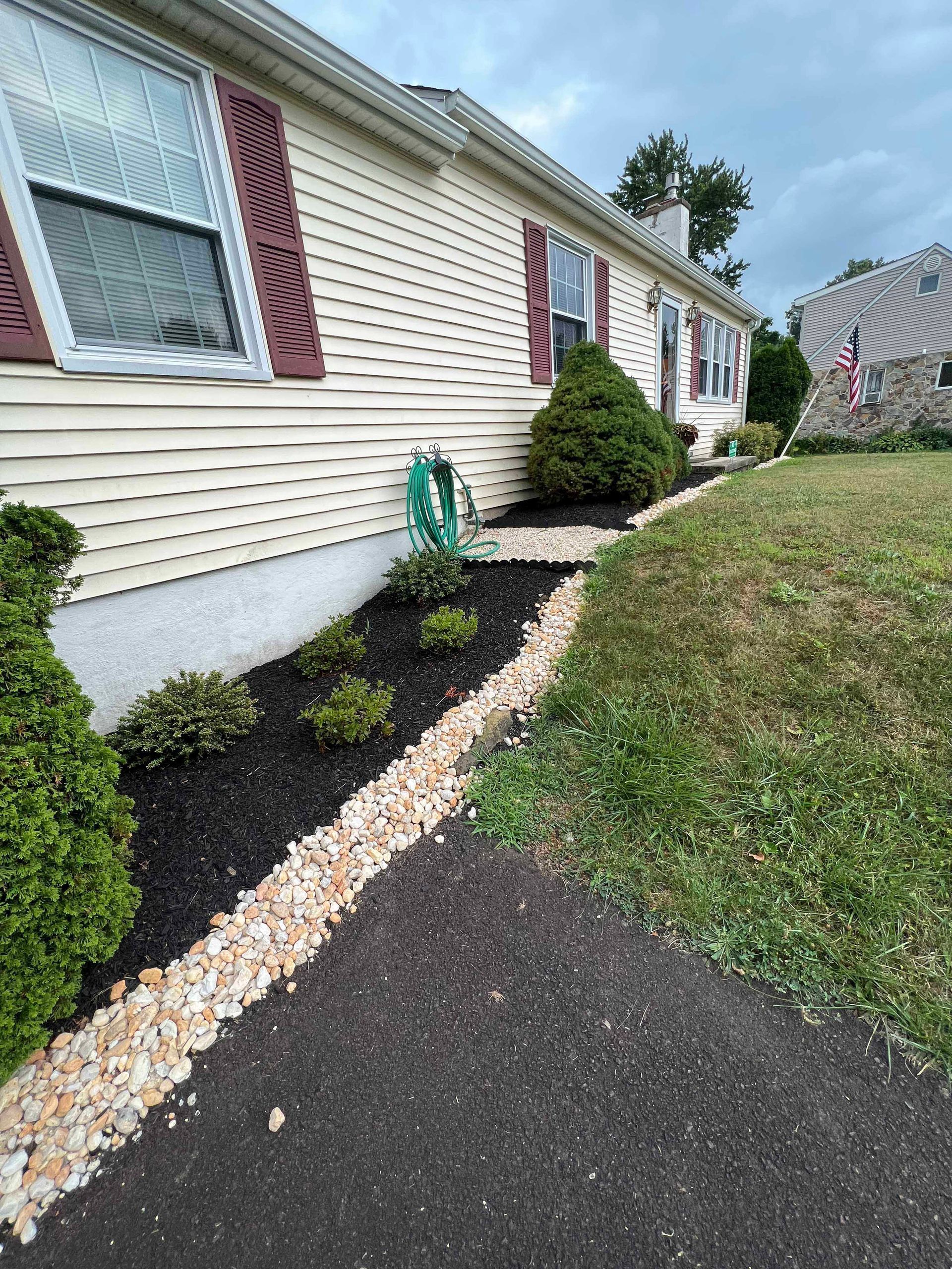 A house with a walkway leading to it and a hose on the side of it.