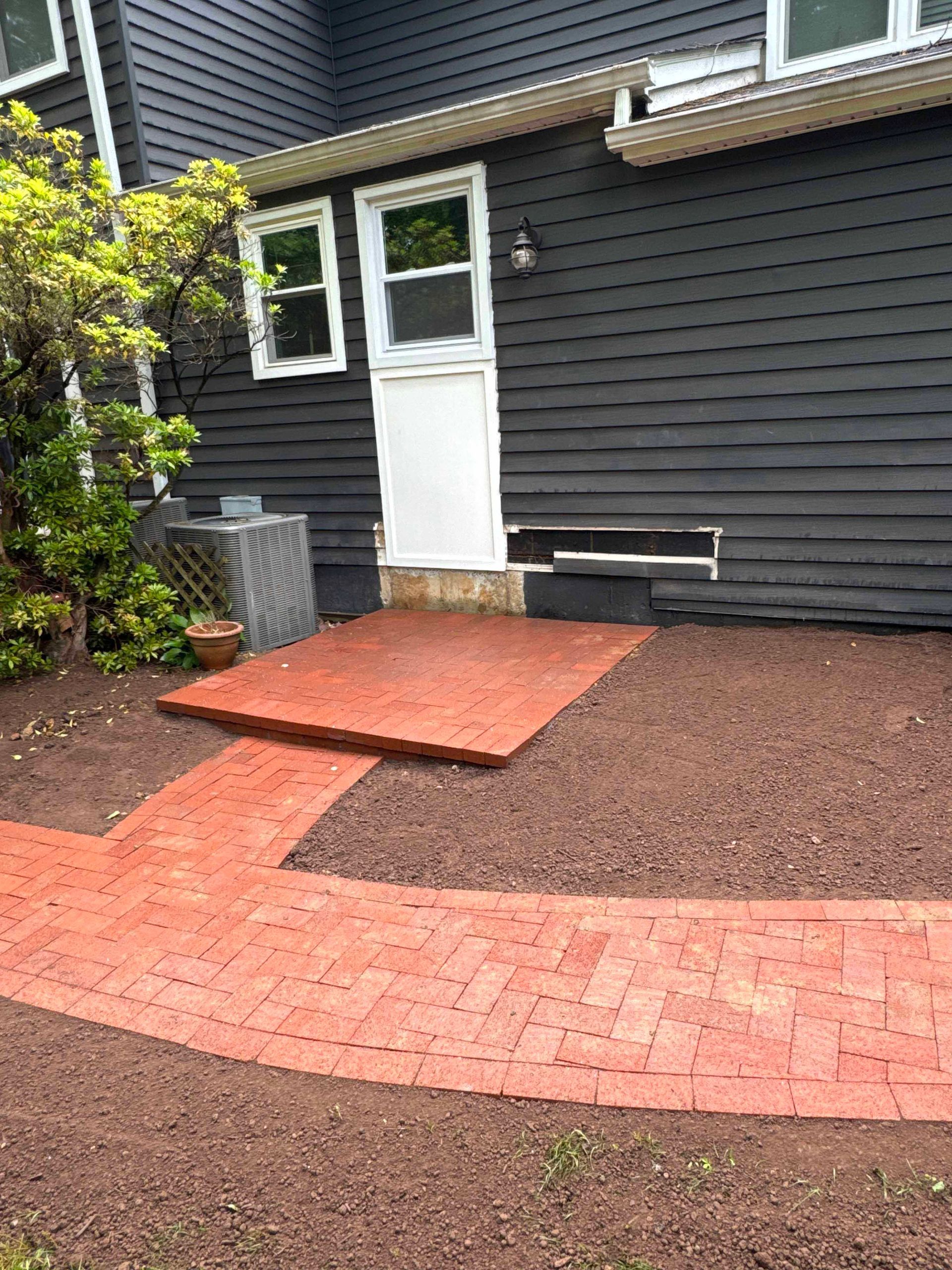 A brick walkway leading to the front door of a house.