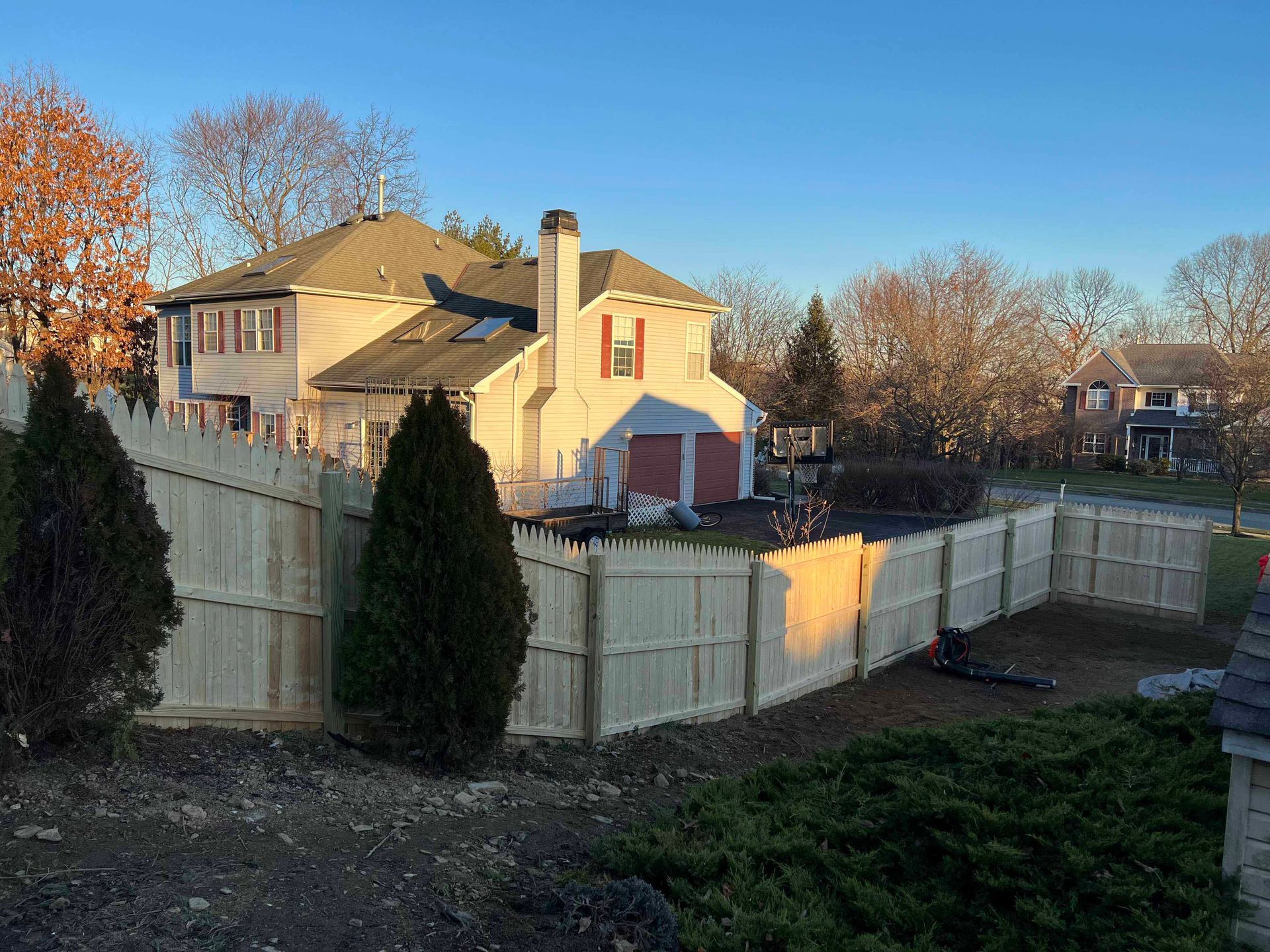 A large house with a wooden fence in front of it.