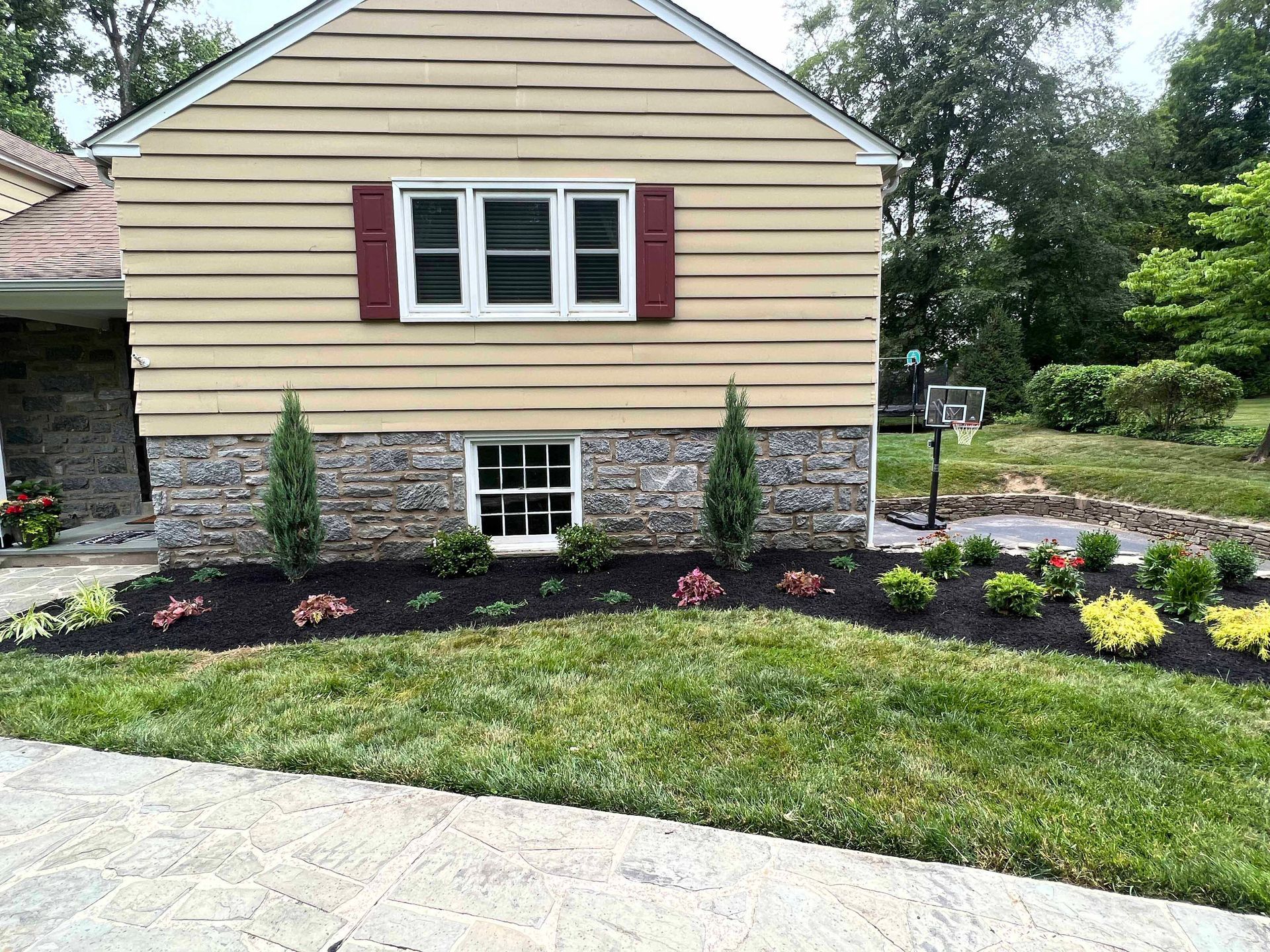 A house with a lush green lawn in front of it.