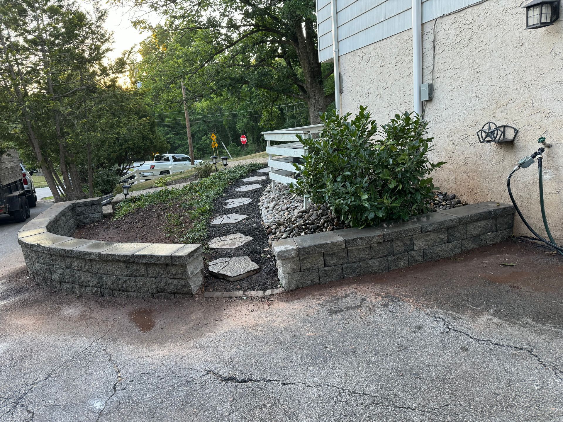 A brick wall with a hose attached to it in front of a house.
