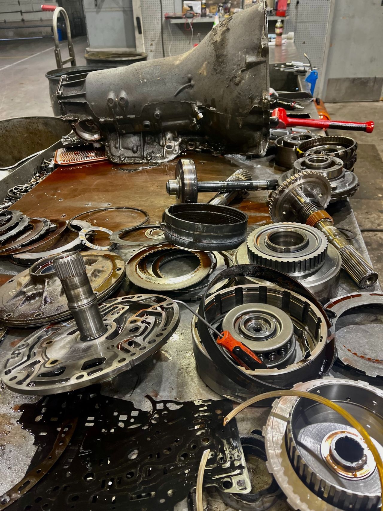 A bunch of dirty parts are sitting on a table.