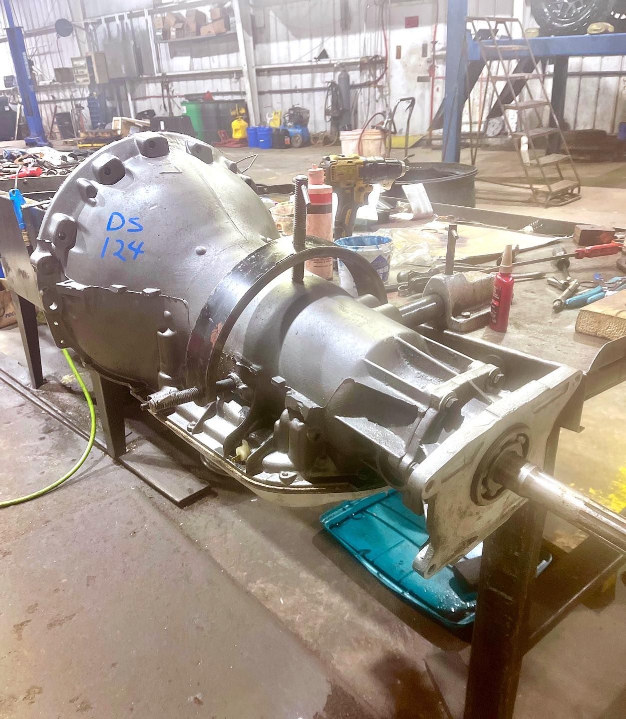 A large engine is sitting on a table in a garage.