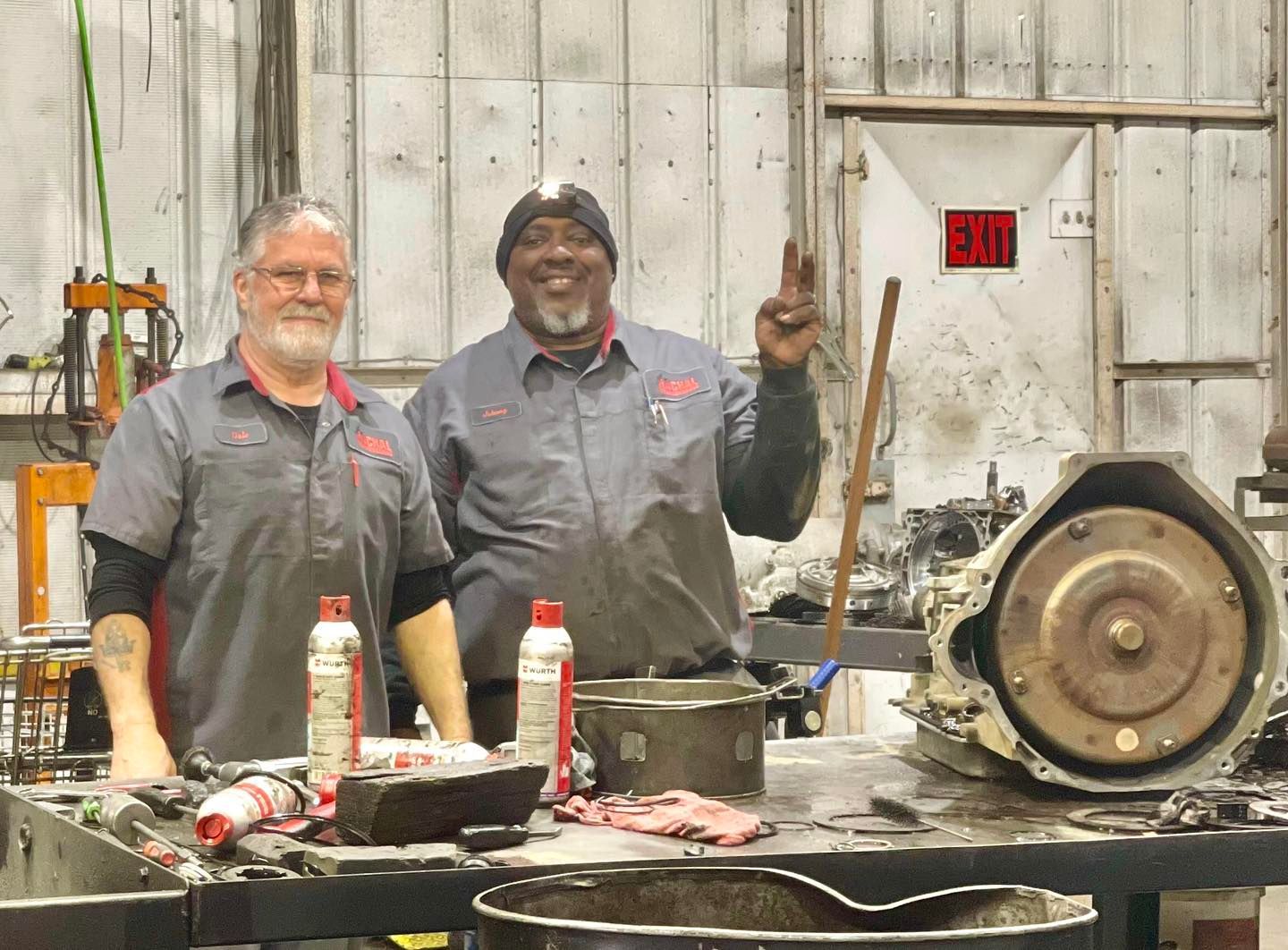 Two men are standing next to each other in a garage.