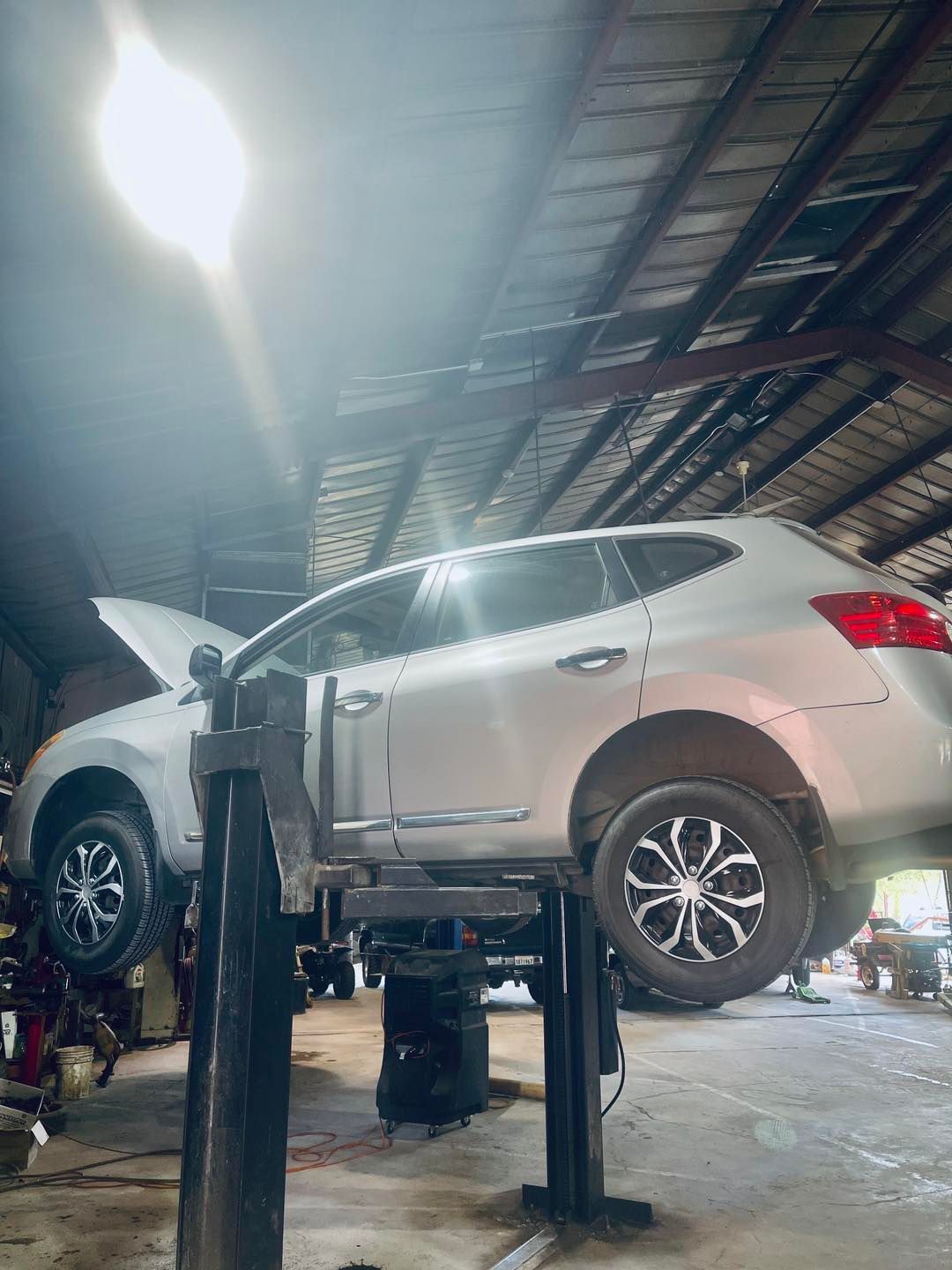 A car is sitting on a lift in a garage.